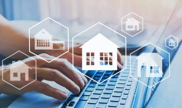 Pandemic Continues to Wreak Havoc on Housing Affordability House icons over someone typing on a computer