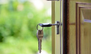 Key in a door with greenery background