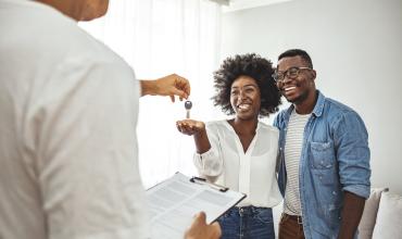 Couple accepting keys from a real estate agent