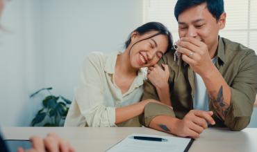 What to Know About an HOA A happy couple sitting at a desk