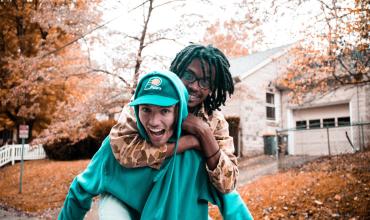 two people smiling on a street 