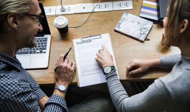 People talking at a table looking at papers