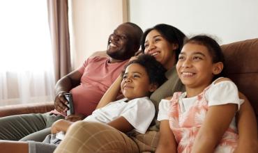 A family sitting on the couch together