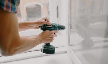 Man using power tool on door