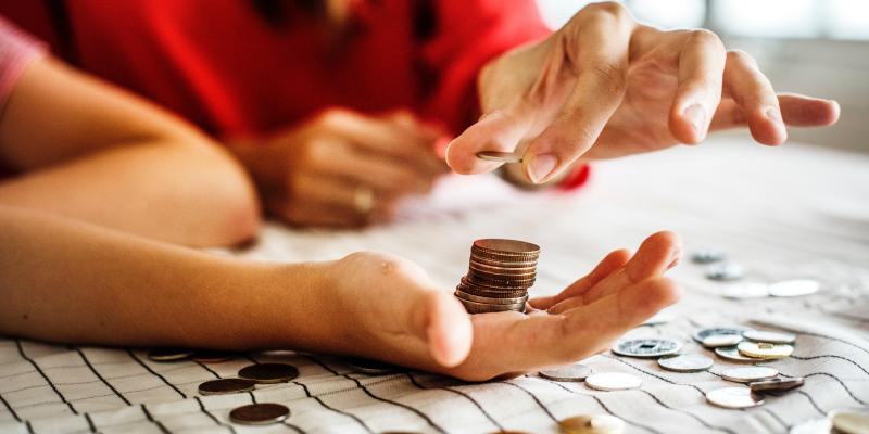 People stacking coins on a table