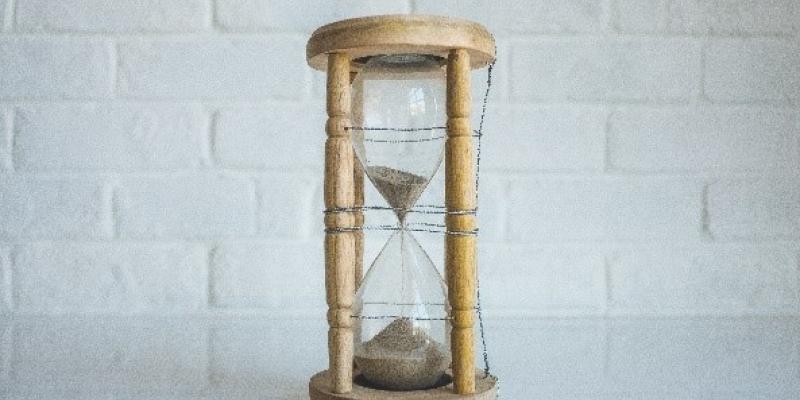 An hour glass with a white brick background