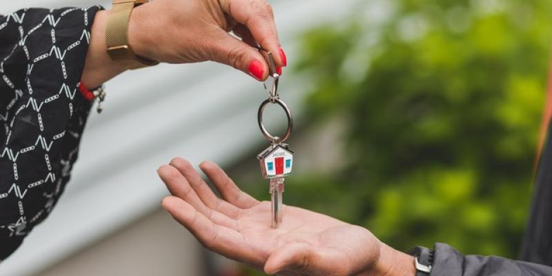 A hand placing a key in another person's hand